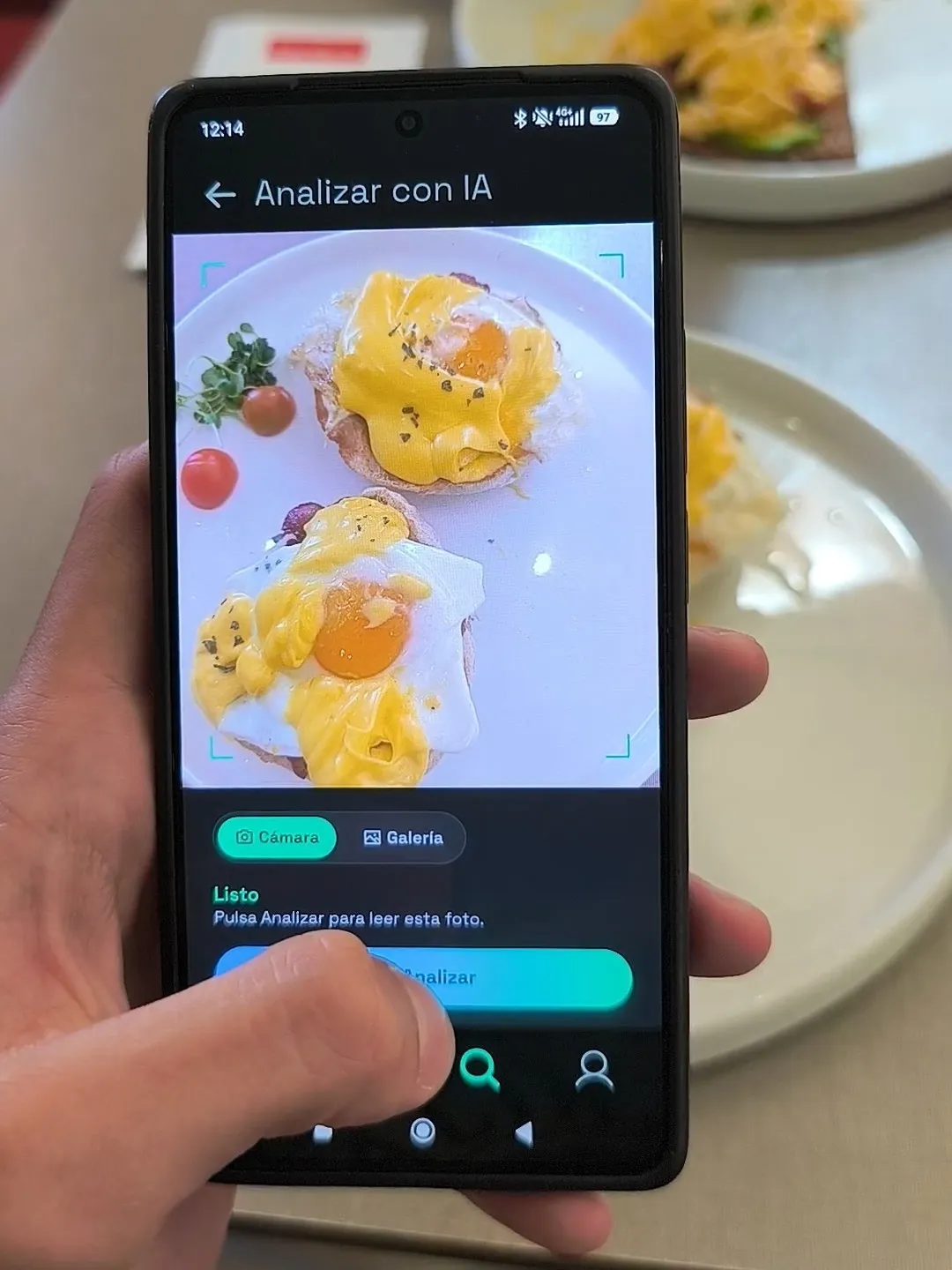 Móvil con MacroLab analizando con IA la foto de un plato de huevos benedictinos